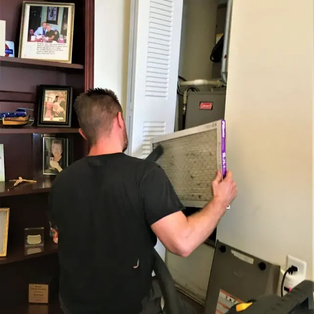 Technician replacing air filter during service call